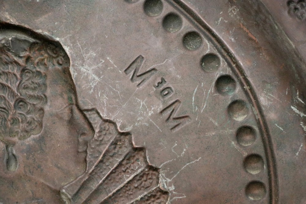 Pair of circular relief-embossed copper wall chargers depicting profile portraits of King Henry IV and Queen Marie de Medicis surrounded by floral and mask borders. View XV