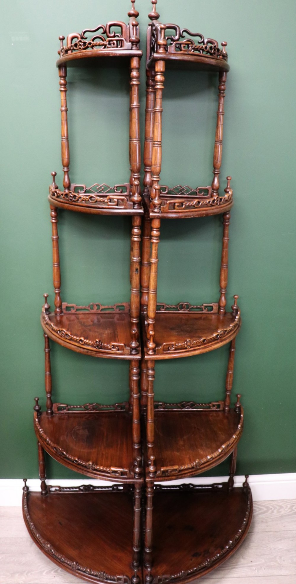A matching pair of Victorian dark wood five-tier corner whatnots featuring turned spindle supports, carved pierced galleries, and decorative finials. View II