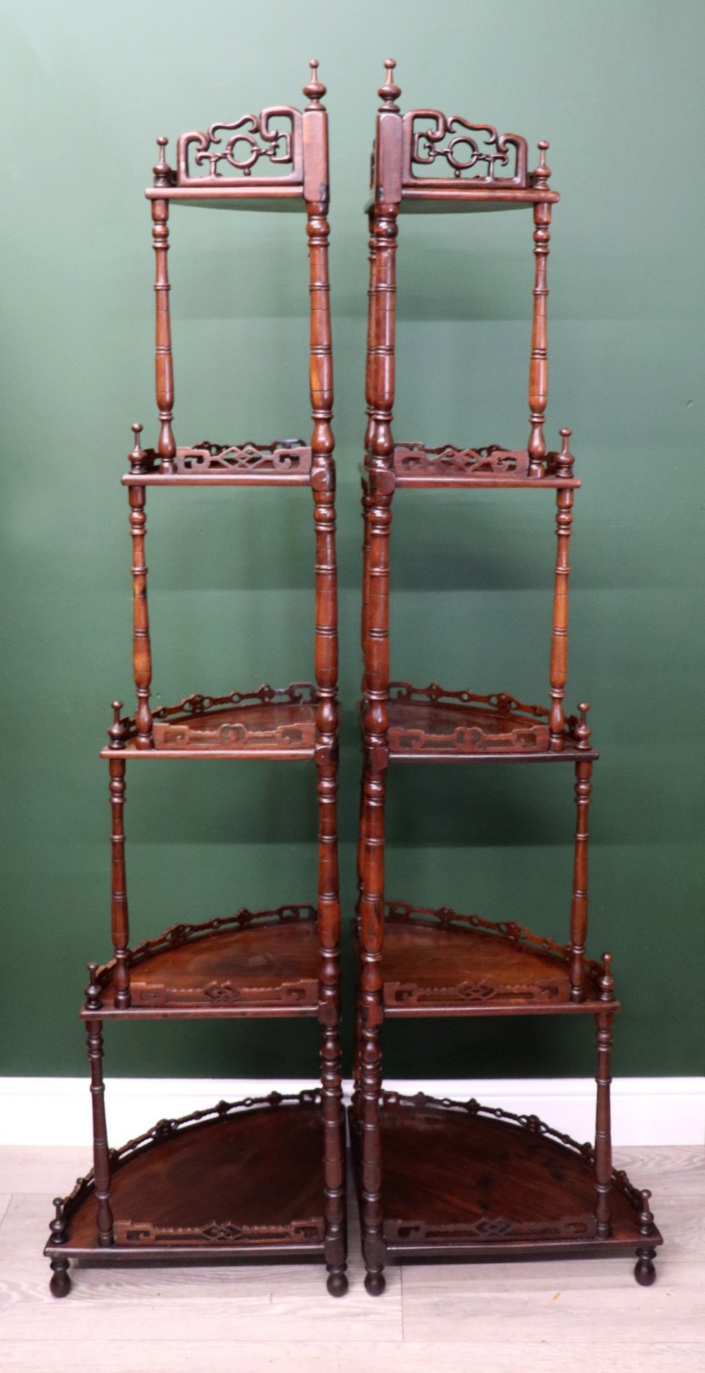 A matching pair of Victorian dark wood five-tier corner whatnots featuring turned spindle supports, carved pierced galleries, and decorative finials. View IV