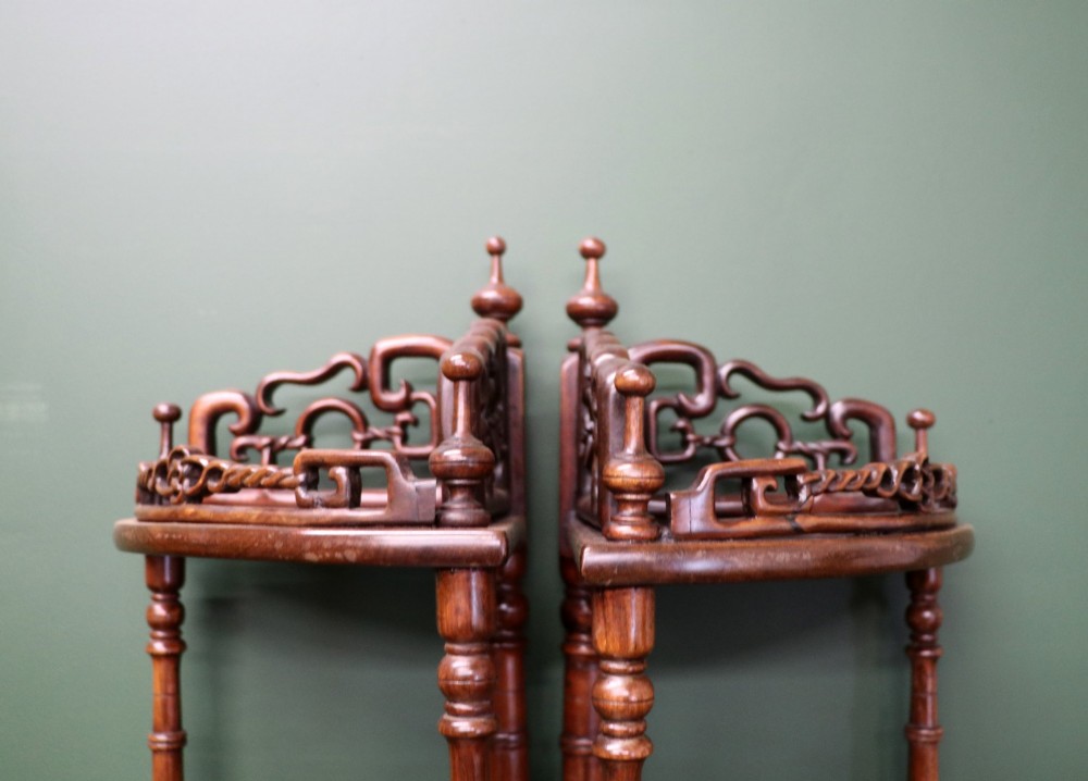A matching pair of Victorian dark wood five-tier corner whatnots featuring turned spindle supports, carved pierced galleries, and decorative finials. View VI