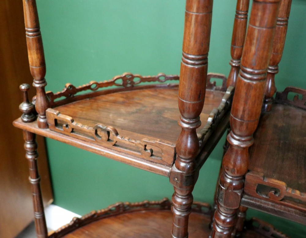 A matching pair of Victorian dark wood five-tier corner whatnots featuring turned spindle supports, carved pierced galleries, and decorative finials. View XII