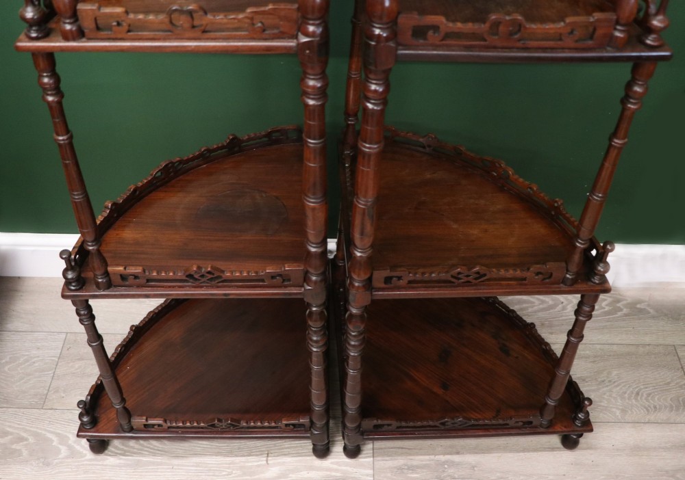 A matching pair of Victorian dark wood five-tier corner whatnots featuring turned spindle supports, carved pierced galleries, and decorative finials. View XIV