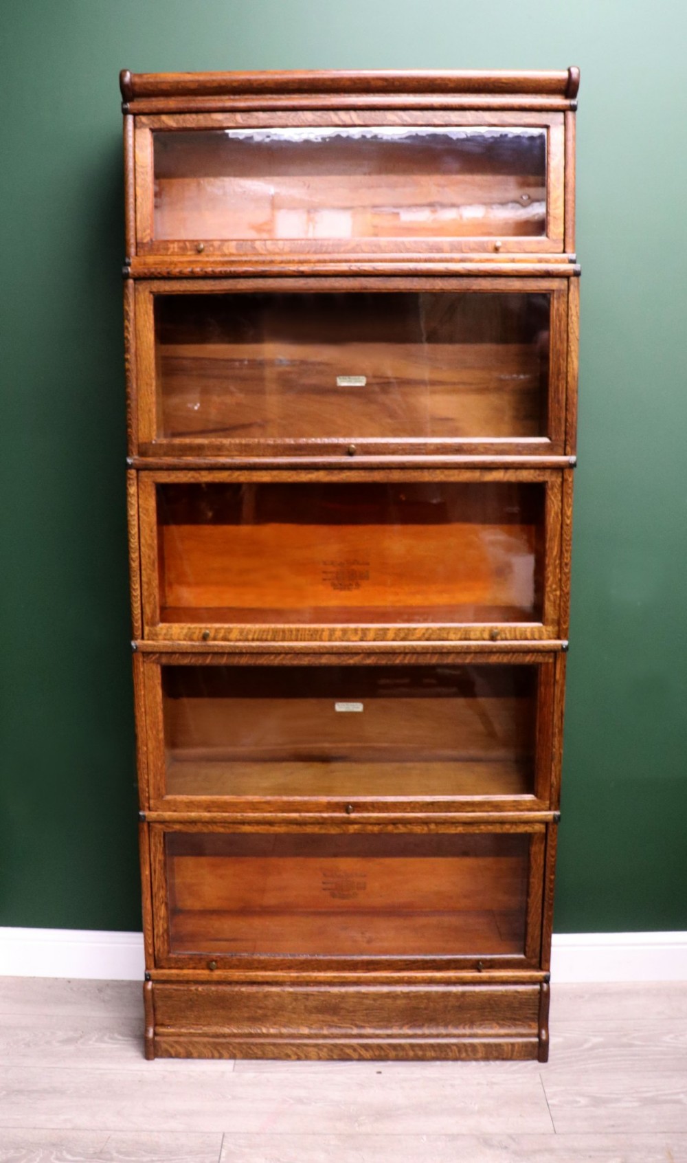 A five-tier Edwardian oak Globe Wernicke stacking bookcase with glass lift-up cabinet doors.