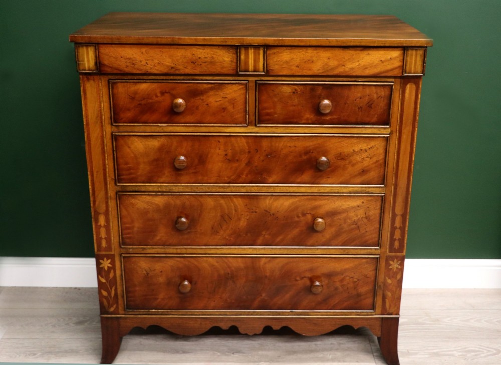 A small Victorian mahogany chest of drawers featuring decorative inlay along the frame, turned wooden knobs, and a shaped apron on curved feet. View II