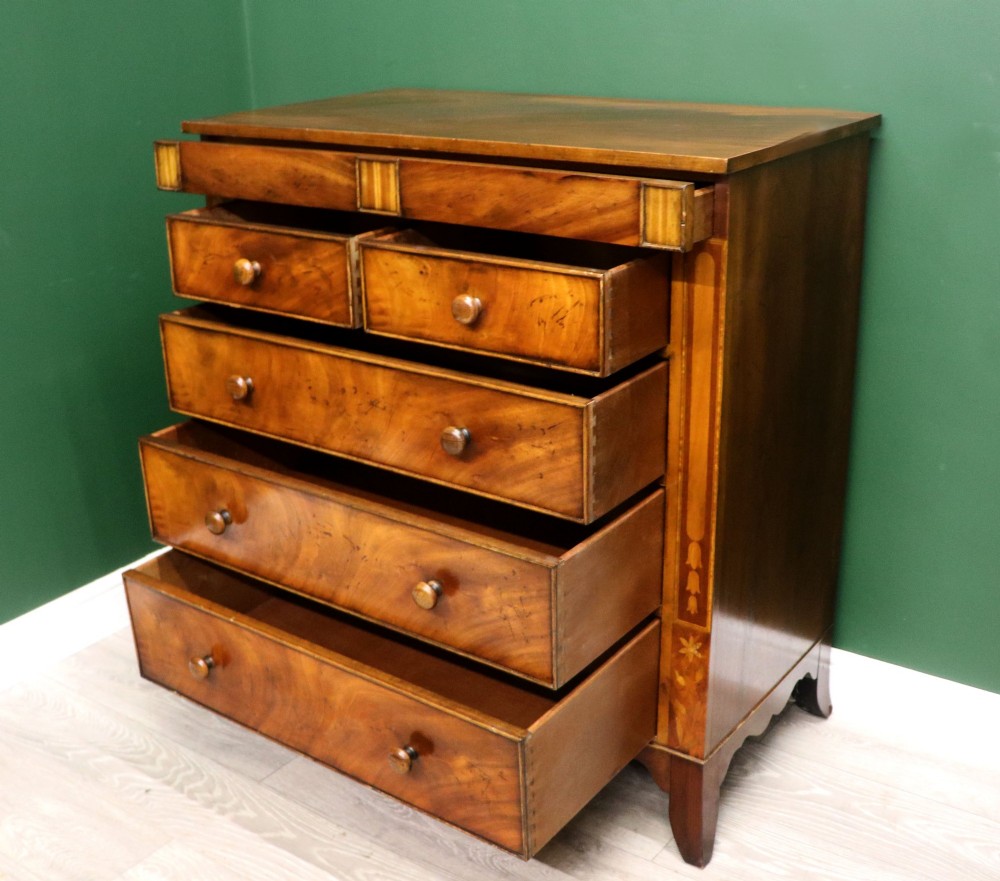 A small Victorian mahogany chest of drawers featuring decorative inlay along the frame, turned wooden knobs, and a shaped apron on curved feet. View VI
