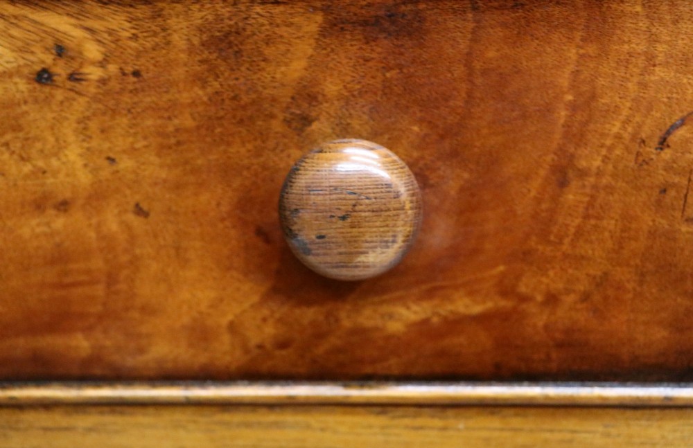 A small Victorian mahogany chest of drawers featuring decorative inlay along the frame, turned wooden knobs, and a shaped apron on curved feet. View IX