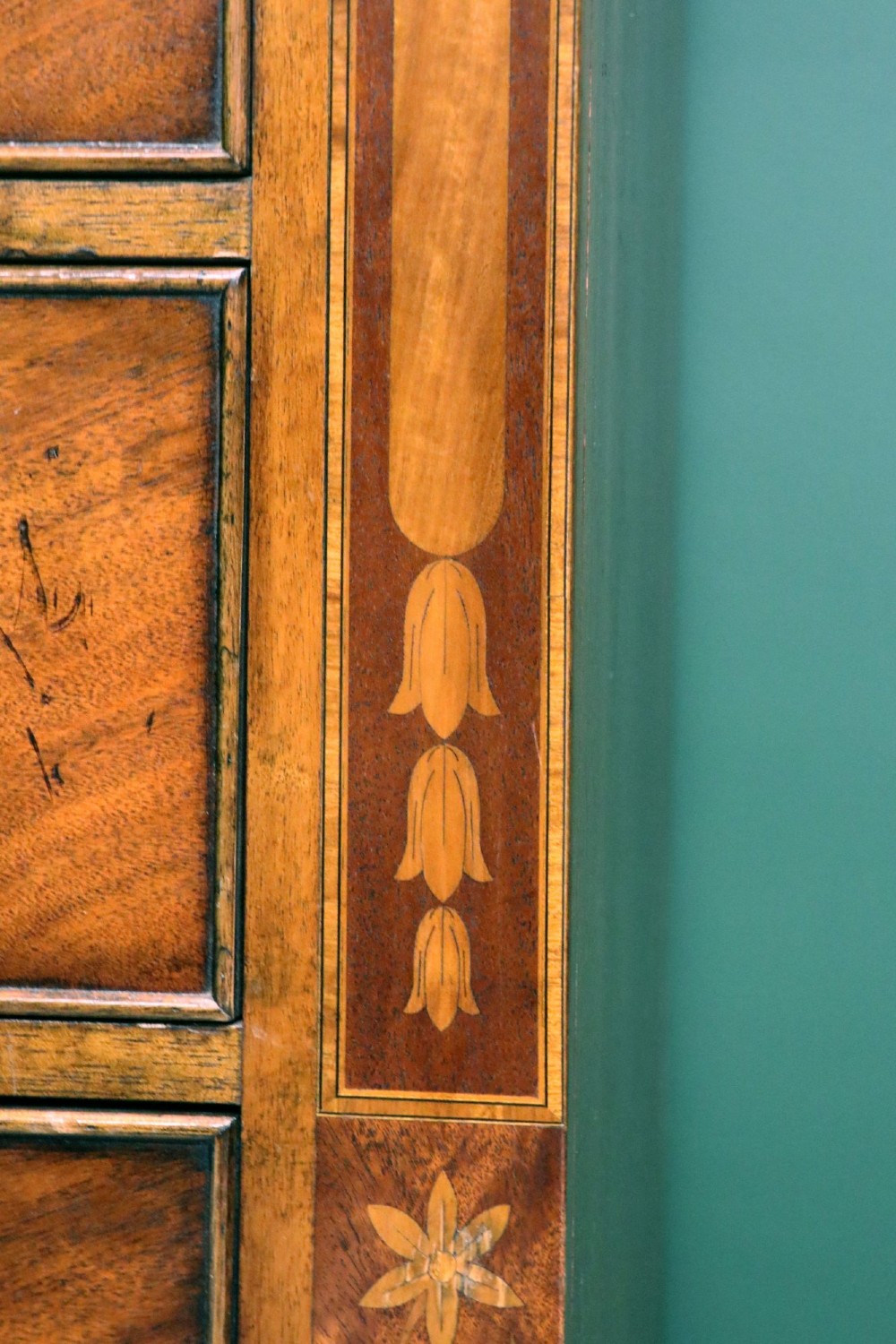 A small Victorian mahogany chest of drawers featuring decorative inlay along the frame, turned wooden knobs, and a shaped apron on curved feet. View XII