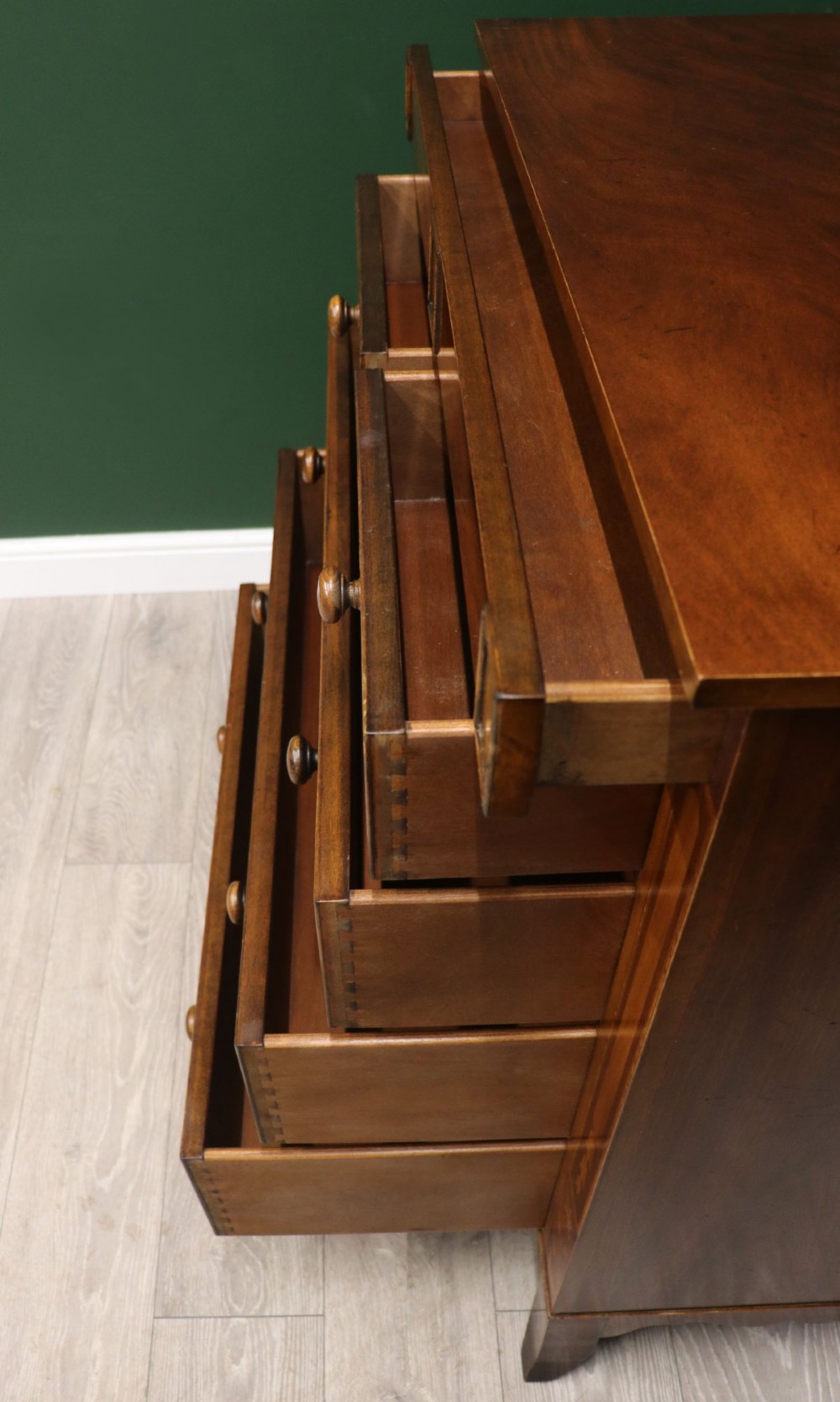 A small Victorian mahogany chest of drawers featuring decorative inlay along the frame, turned wooden knobs, and a shaped apron on curved feet. View XIII