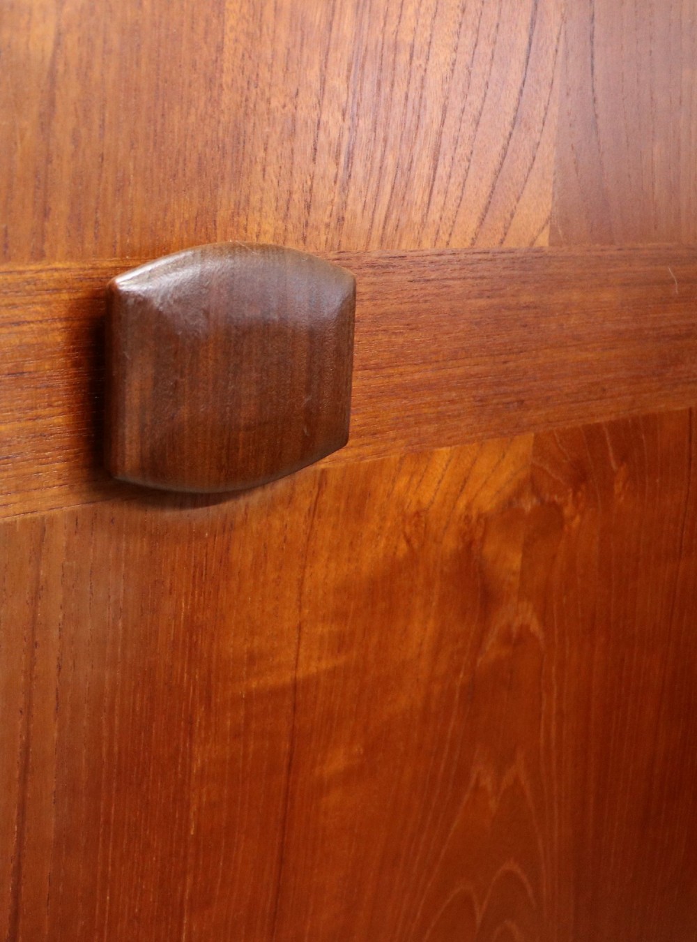 A mid-century teak wood wardrobe featuring two doors with rectangular wooden handles, short tapered legs, and a narrow central full-length mirror. View V