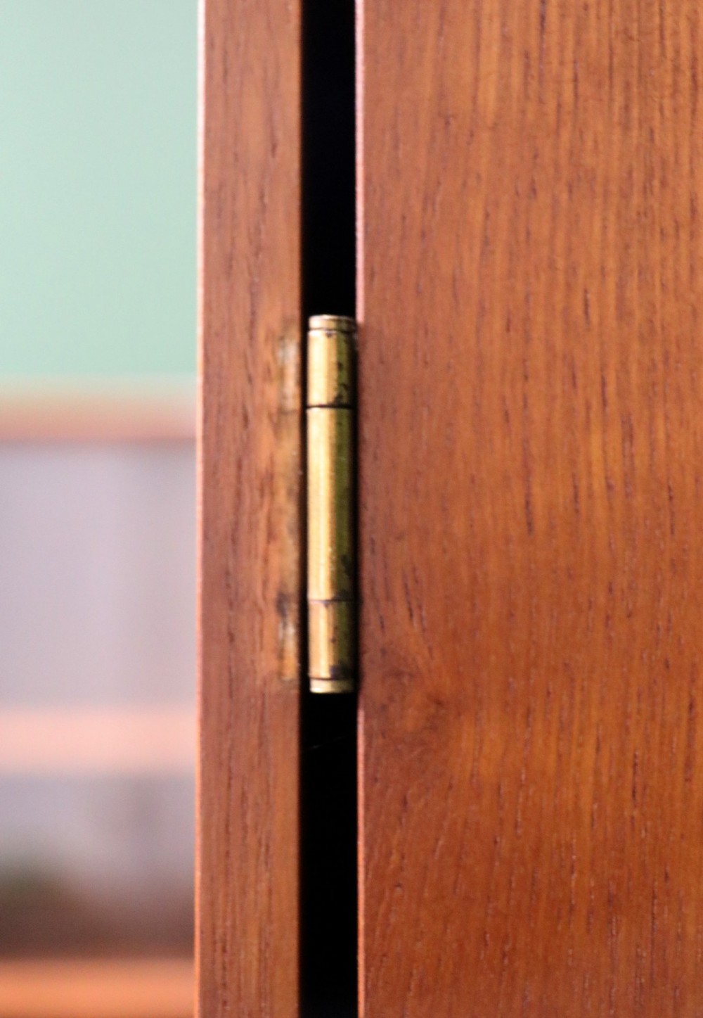 A mid-century teak wood wardrobe featuring two doors with rectangular wooden handles, short tapered legs, and a narrow central full-length mirror. View VIII