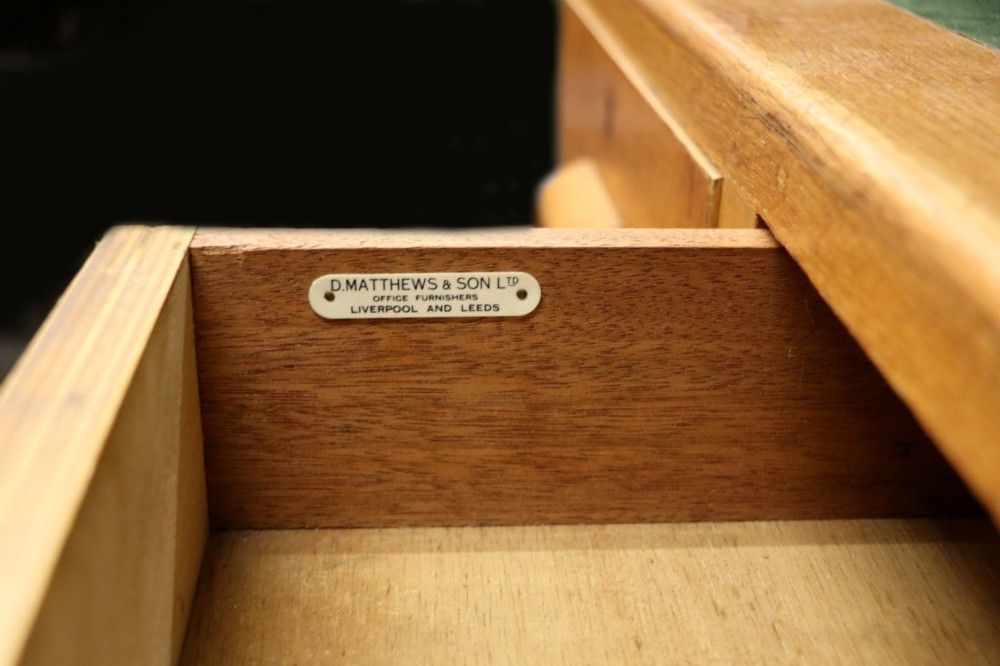 An Art Deco light oak twin pedestal desk featuring a green writing top inset and carved wooden bar drawer handles. View XIV