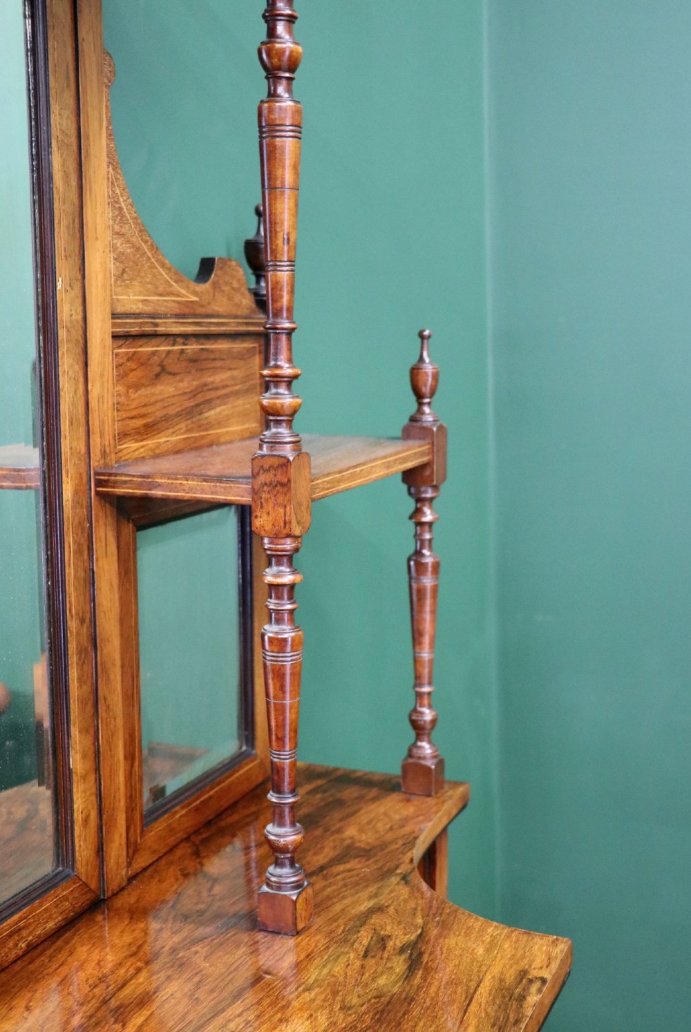 A late Victorian wooden credenza featuring a central inlaid cupboard door, open side shelves, turned spindle pillars, and a multi-pane mirrored back with a fretwork gallery top. View V