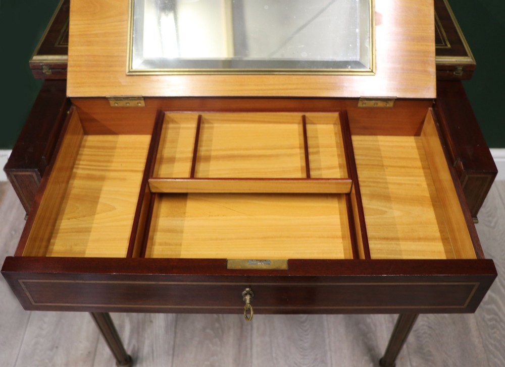A late nineteenth-century French wooden vanity table featuring an open hinged lid with a mirror, interior satinwood compartments, and slender fluted legs. View X