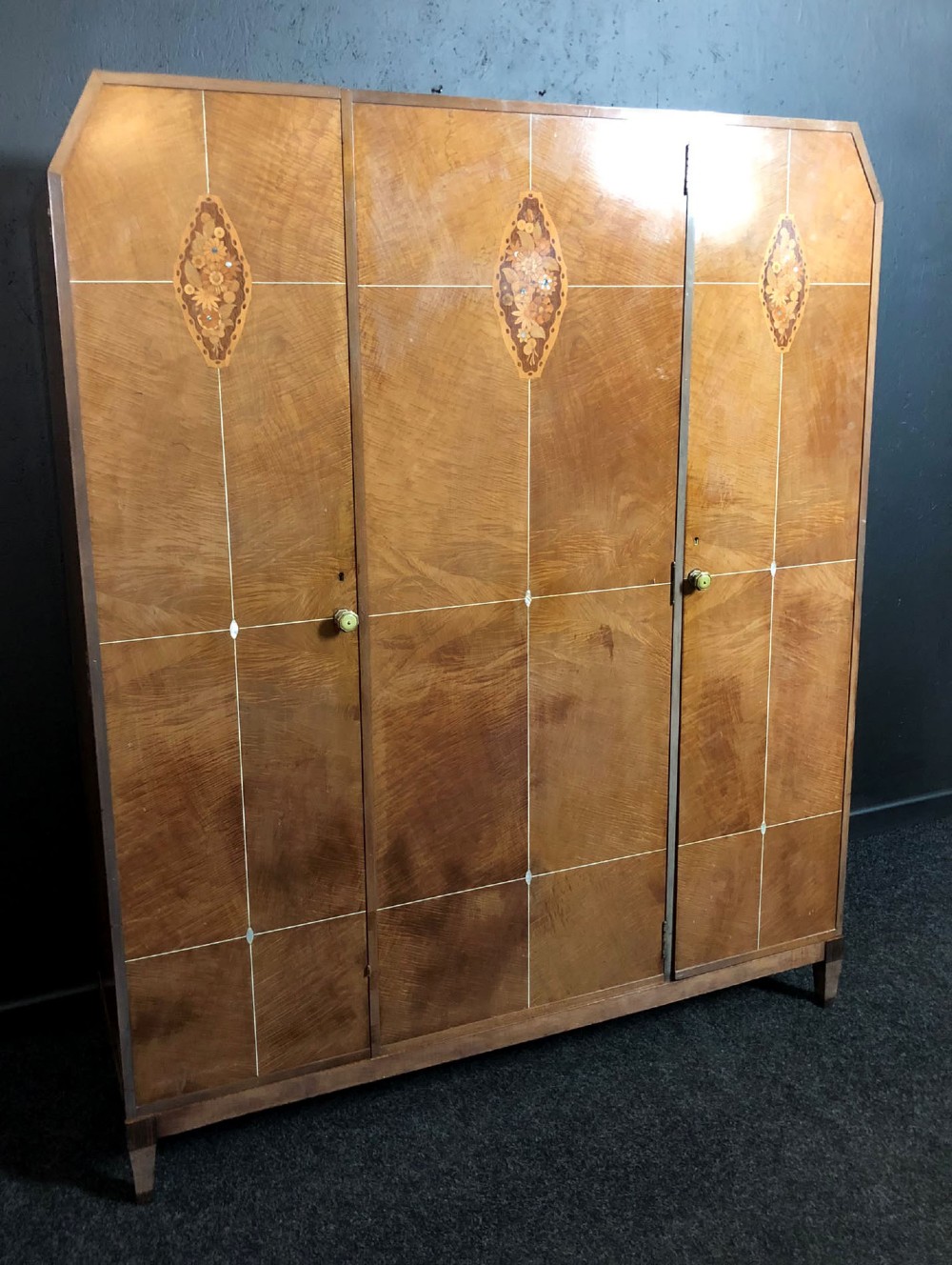An Art Deco three-door walnut wardrobe featuring geometric panel veneers and oval floral marquetry inlays. View IV