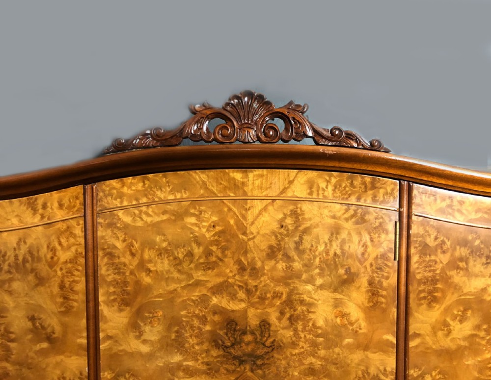 A large Queen Anne revival three-door wardrobe crafted with highly figured burr walnut veneer, featuring carved cresting and decorative metal escutcheons. View VII