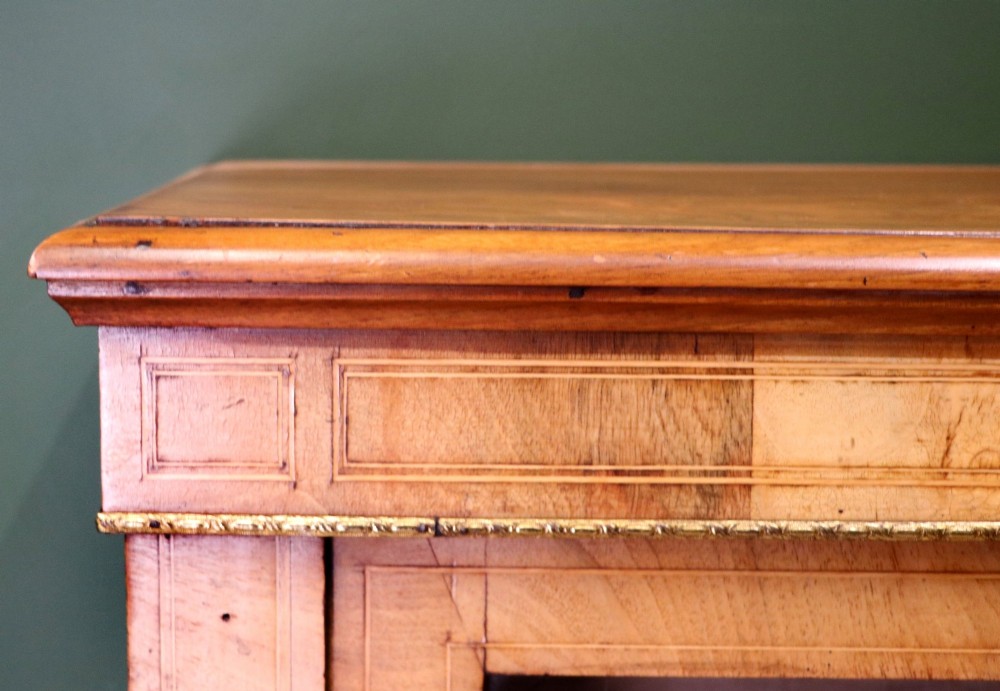 A mid-Victorian low walnut veneered bookcase featuring two glass glazed doors, marquetry inlay along the frieze, and brass trim detailing. View V