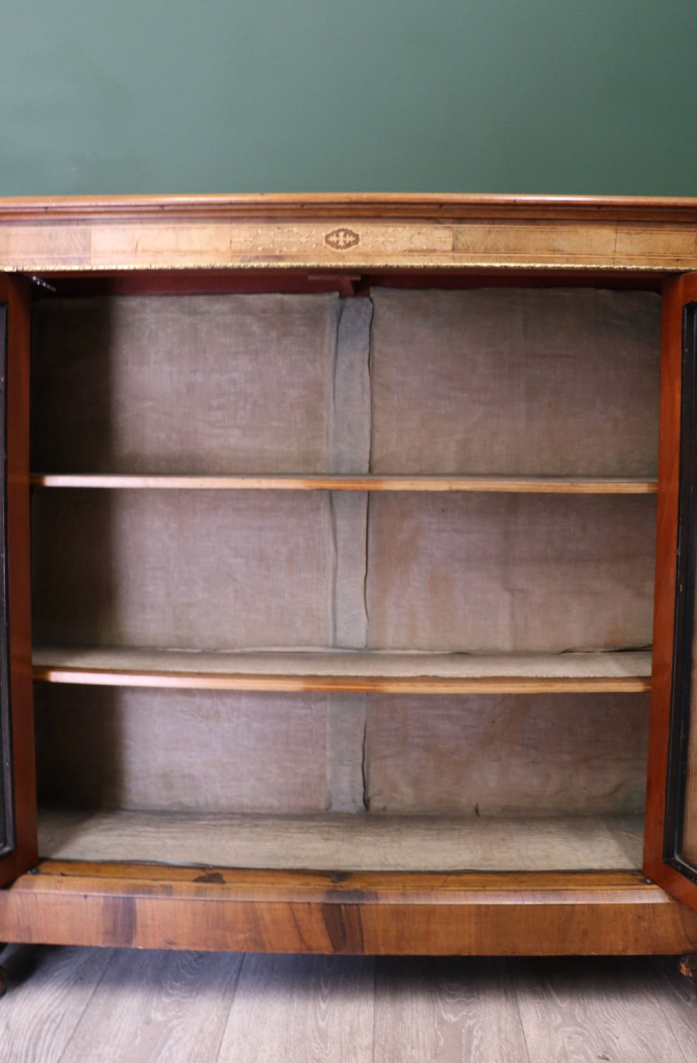 A mid-Victorian low walnut veneered bookcase featuring two glass glazed doors, marquetry inlay along the frieze, and brass trim detailing. View XI