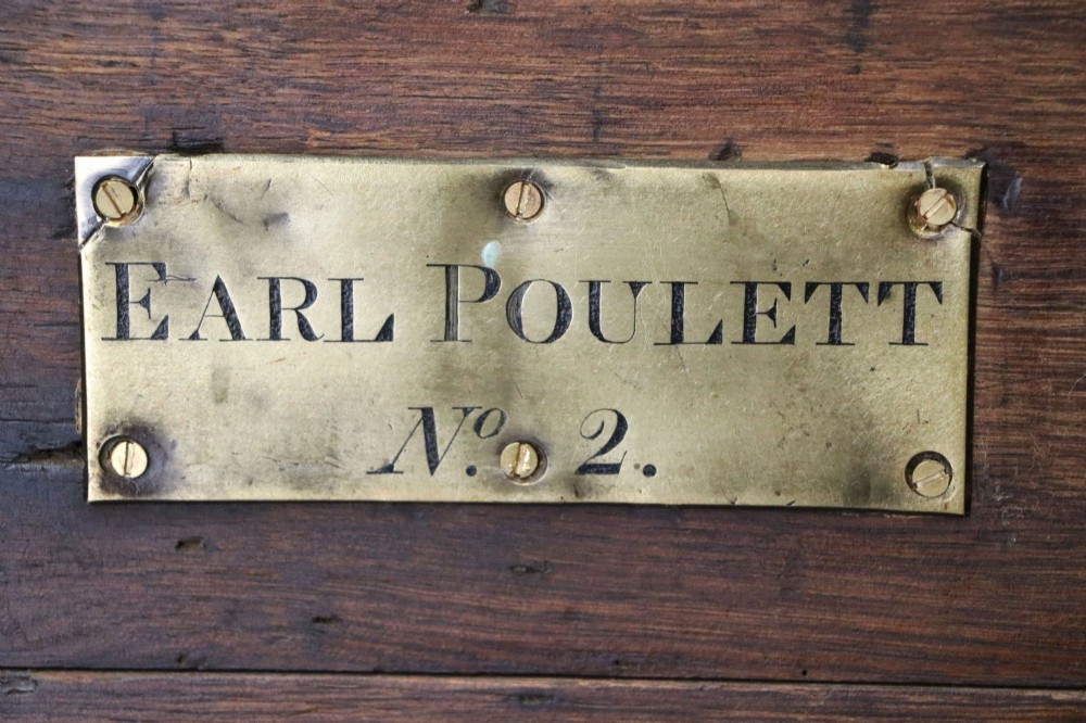 A 19th-century dark oak storage chest reinforced with black iron strapping and featuring a central brass plaque. View VII
