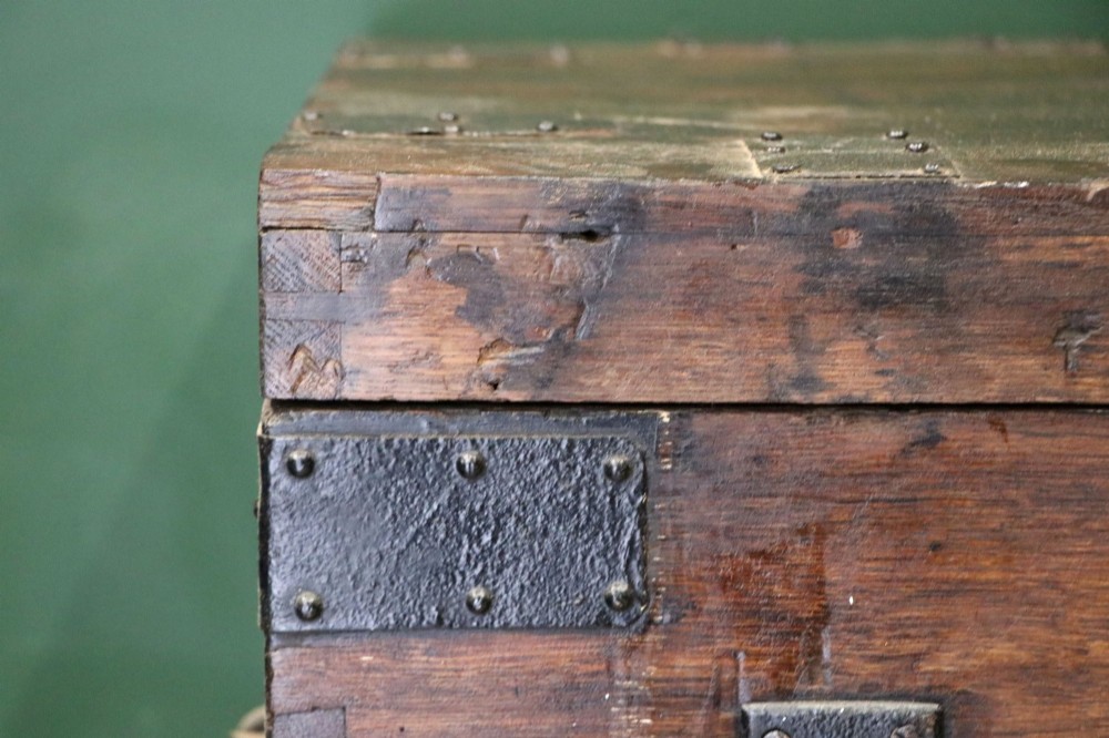 A 19th-century dark oak storage chest reinforced with black iron strapping and featuring a central brass plaque. View IX