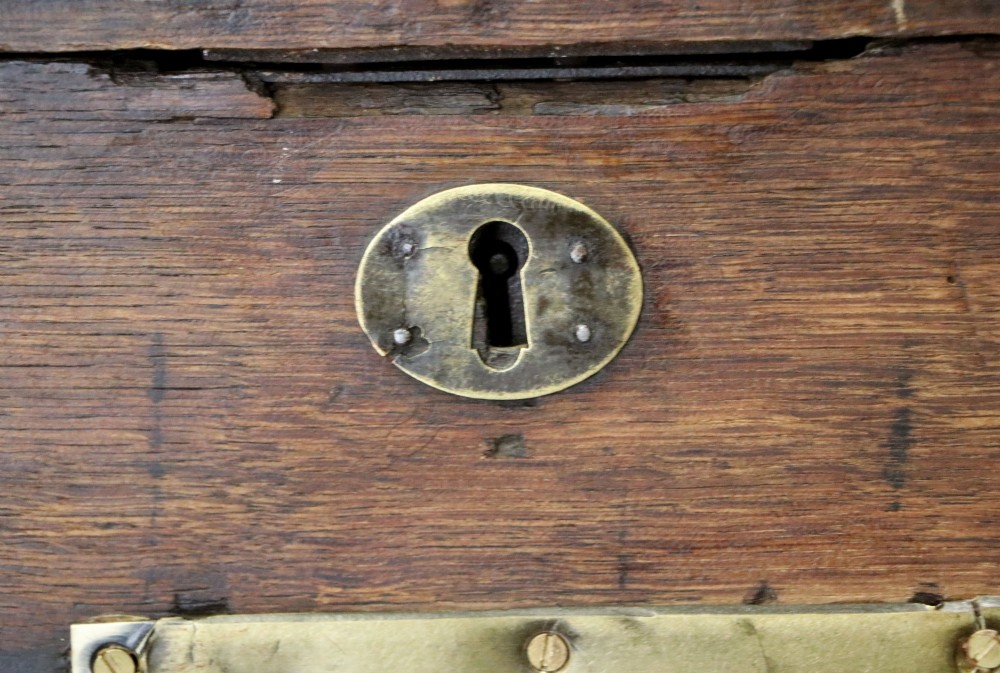A 19th-century dark oak storage chest reinforced with black iron strapping and featuring a central brass plaque. View XI