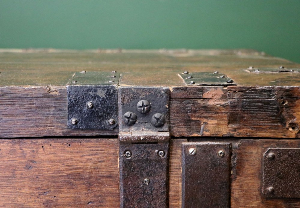 A 19th-century dark oak storage chest reinforced with black iron strapping and featuring a central brass plaque. View XII