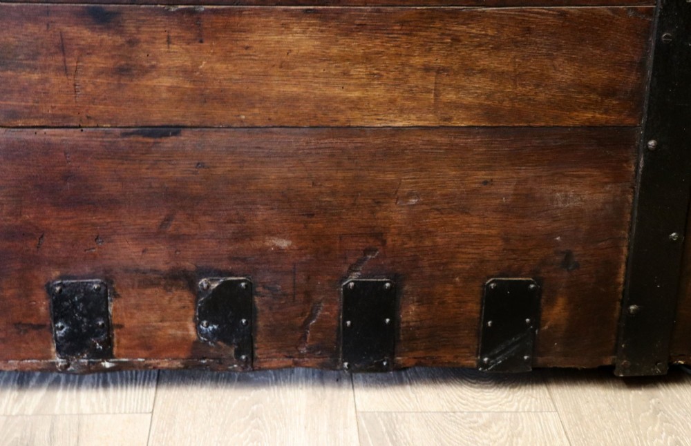 A 19th-century dark oak storage chest reinforced with black iron strapping and featuring a central brass plaque. View XV