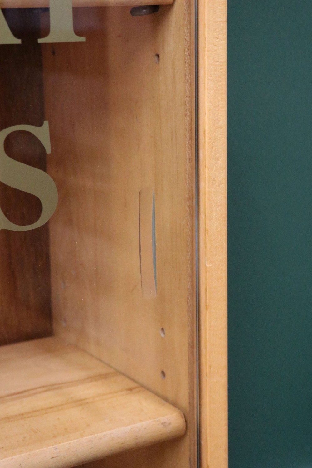 A low mid-century light oak bookcase with sliding glass doors featuring printed gold typography reading The Times and The Sunday Times London. View XII