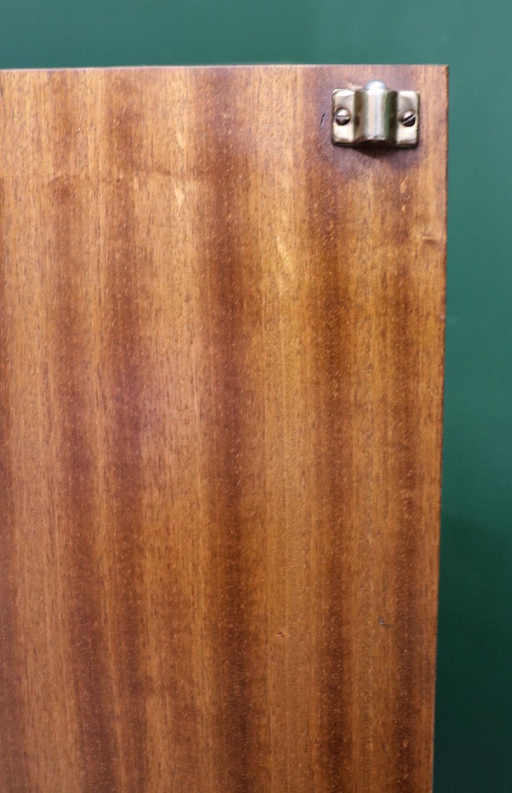 A low mid-century teak bookcase with two sliding glass doors featuring printed lettering alongside a single solid teak cupboard door. View XII