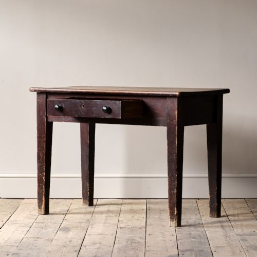fig 1. A nineteenth-century dark brown pine side table featuring a single drawer with two black turned wooden knobs and tapered square legs.