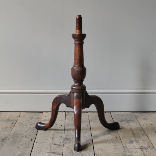fig 1. A George III dark mahogany circular tilt-top tripod table positioned vertically above a turned central column and three cabriole legs.