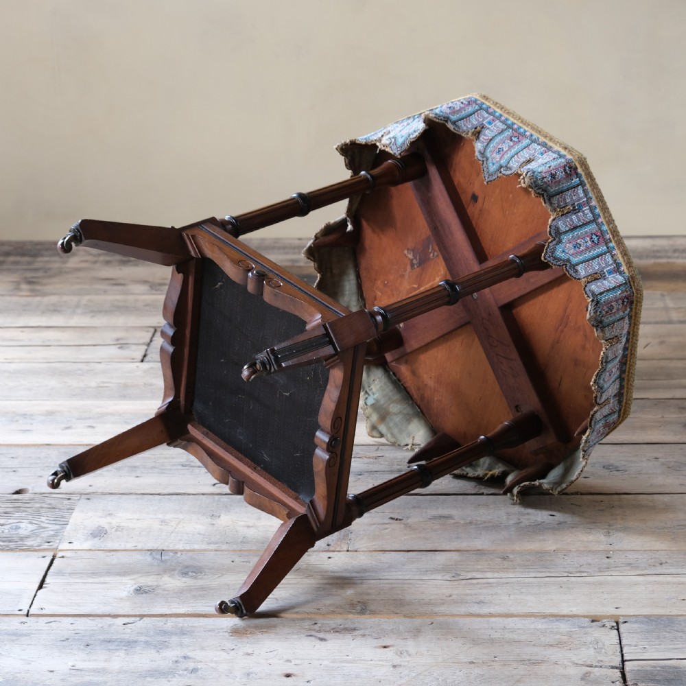 A 19th-century octagonal Aesthetic Movement side table with turned ebonised legs, a lower shelf, and a beaded tapestry top. View V