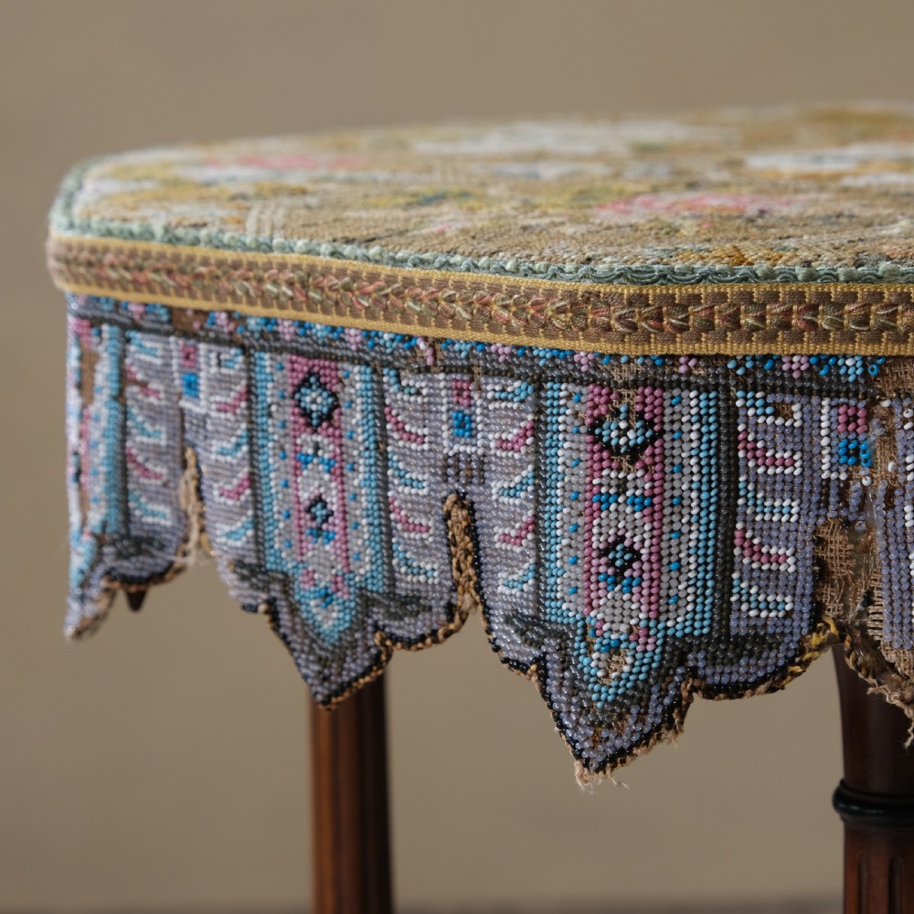 A 19th-century octagonal Aesthetic Movement side table with turned ebonised legs, a lower shelf, and a beaded tapestry top. View VII