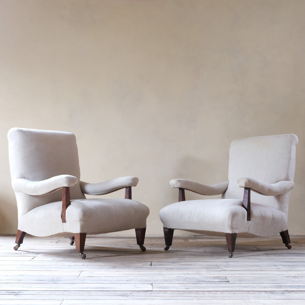 A pair of large Howard style open armchairs