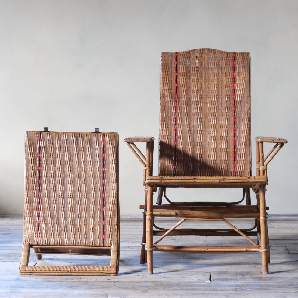 An antique French bamboo reclining chaise longue with a woven cane seat, raised armrests, and extending footrest. View VII