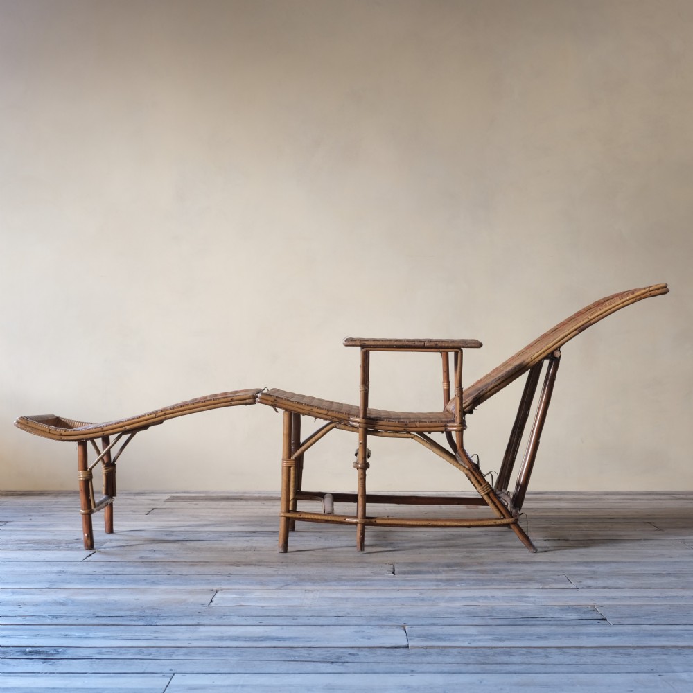 An antique French bamboo reclining chaise longue with a woven cane seat, raised armrests, and extending footrest. View VIII