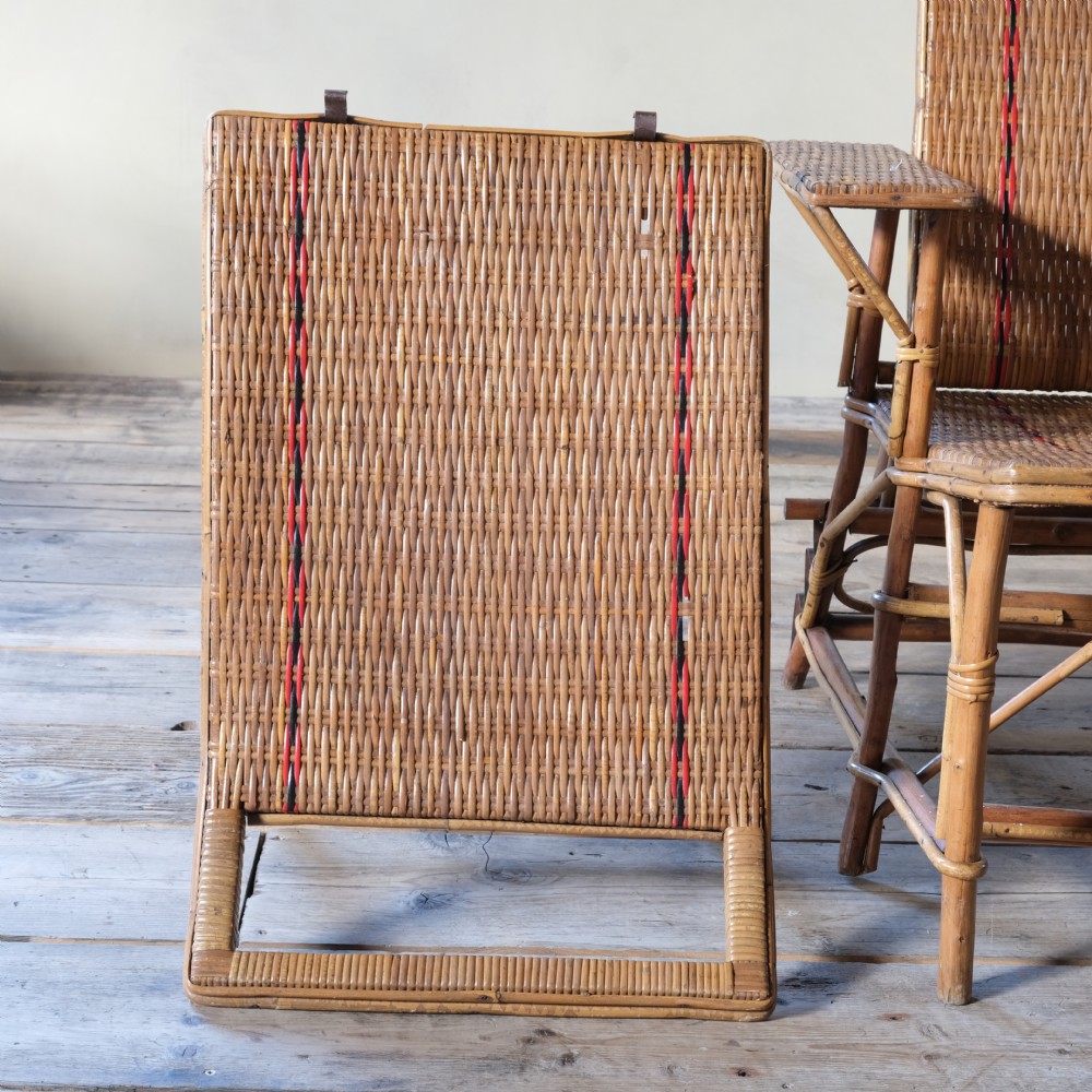 An antique French bamboo reclining chaise longue with a woven cane seat, raised armrests, and extending footrest. View X