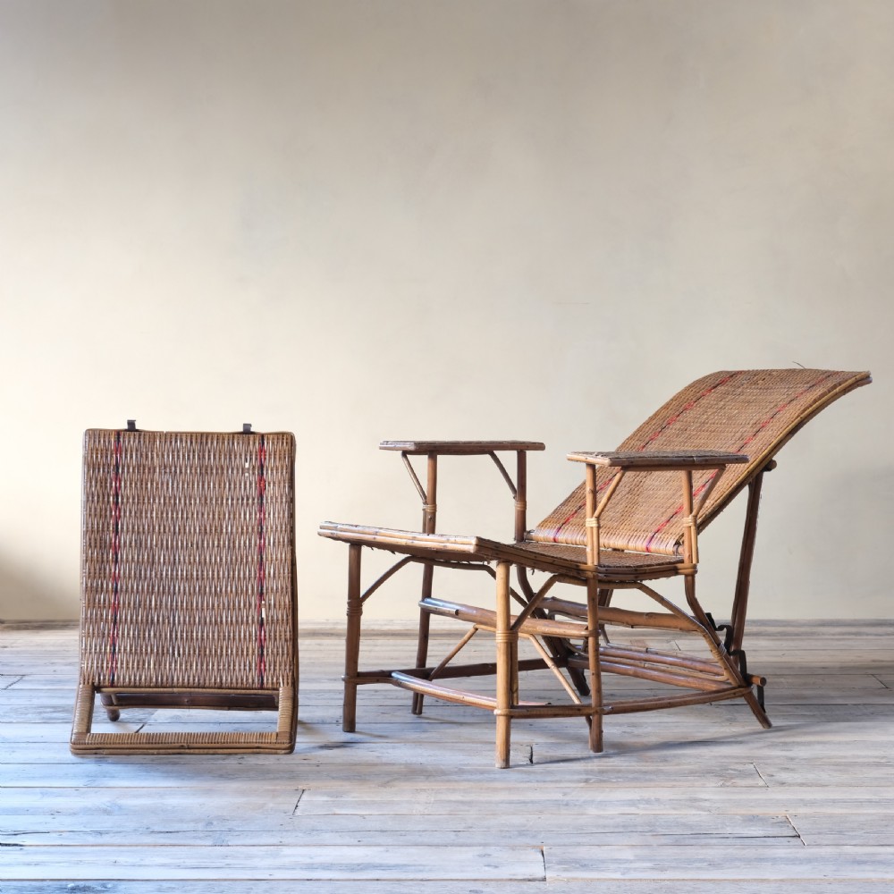 An antique French bamboo reclining chaise longue with a woven cane seat, raised armrests, and extending footrest. View XIII