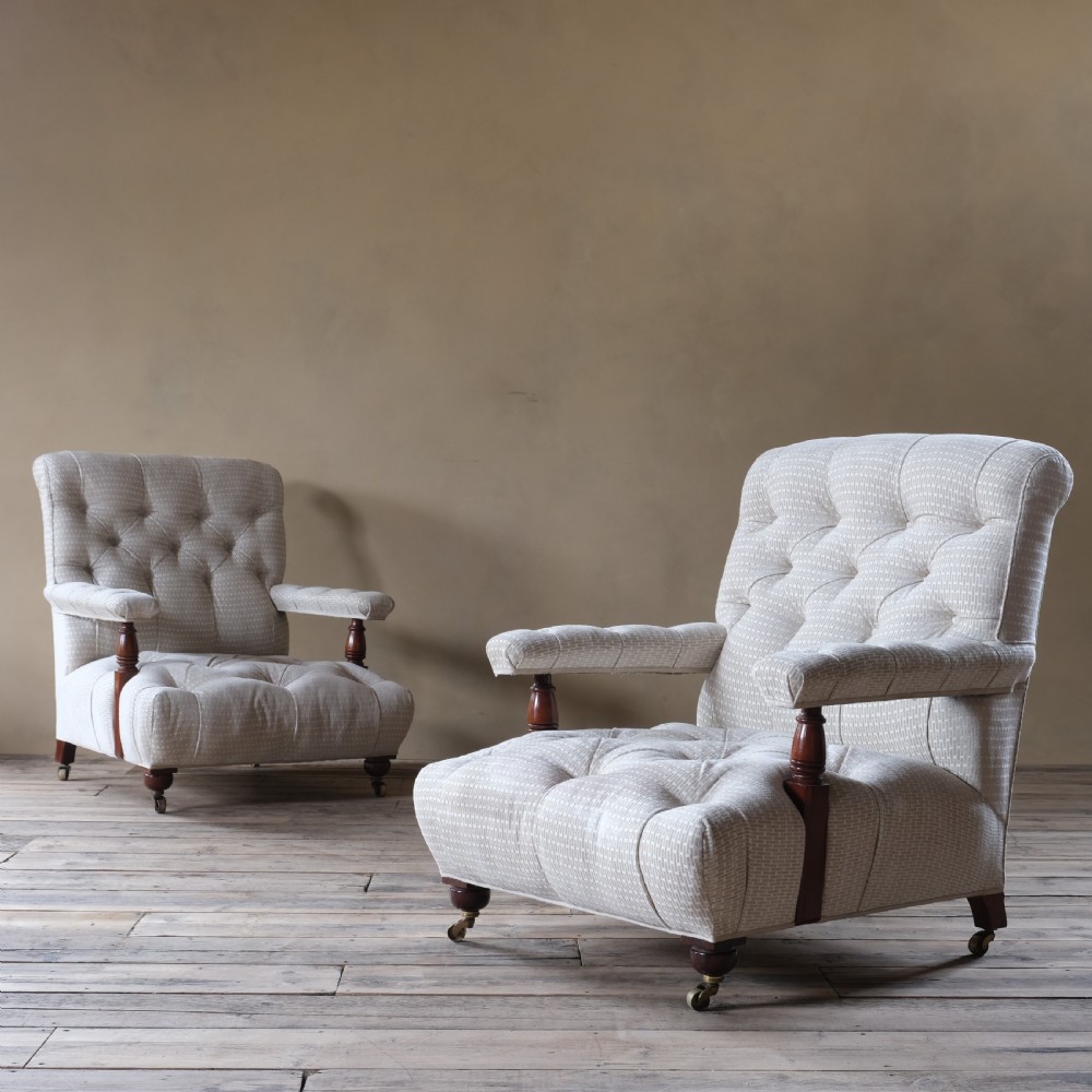 A pair of 19th century fully buttoned open armchairs