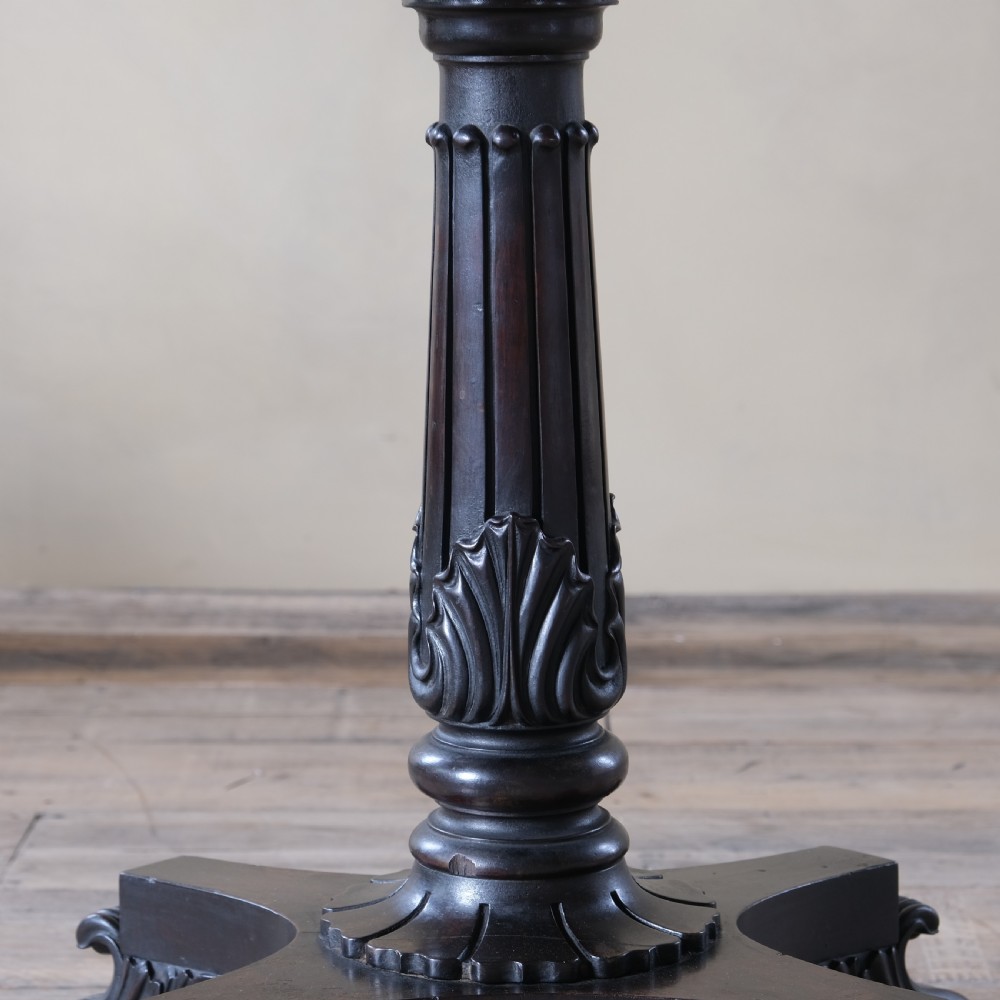A dark rosewood Regency teapoy featuring gadrooned moulding, a carved column pedestal, and four scrolled legs. View II