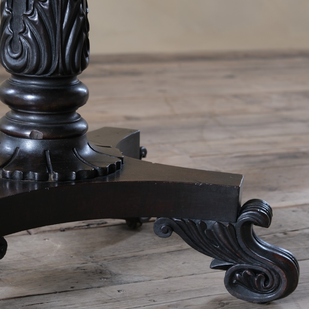 A dark rosewood Regency teapoy featuring gadrooned moulding, a carved column pedestal, and four scrolled legs. View III