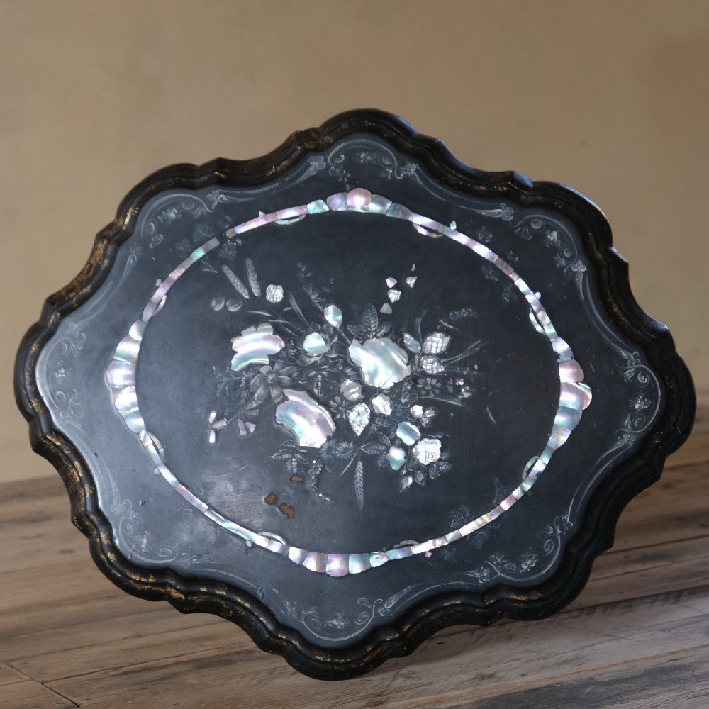 A 19th-century black lacquer papier-mache side table featuring a scalloped floral inlaid top on a turned pedestal with scroll feet. View VII