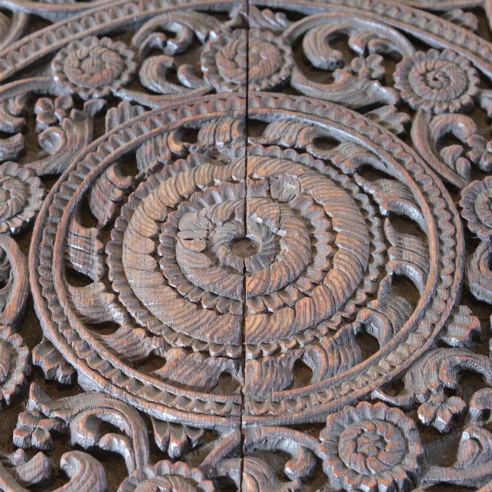 A late 19th-century Burmese dark teak two-tier side table with hand-carved mythological figure supports and circular foliate-carved surfaces. View VIII
