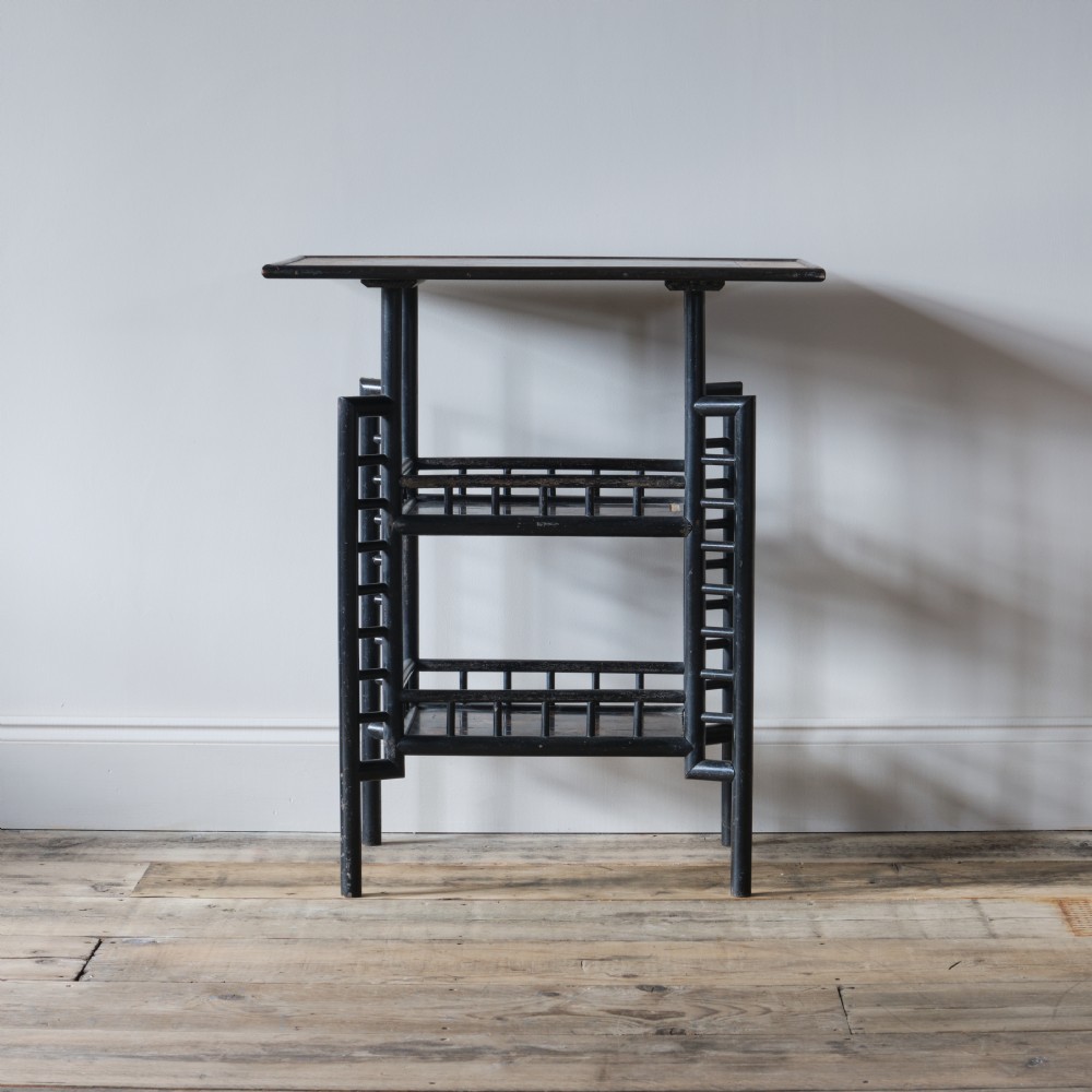 A Victorian Anglo-Japanese ebonised black lacquered three-tier side table featuring lattice side panels and spindled shelf galleries. View II