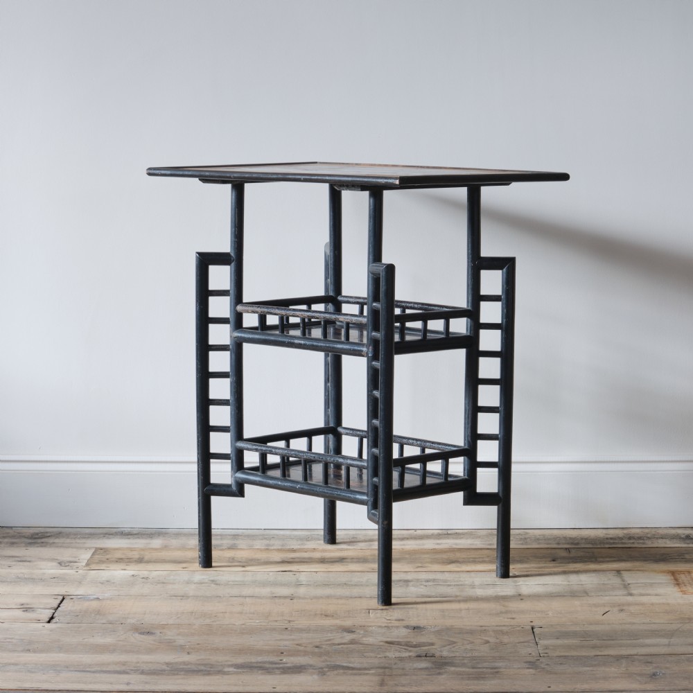 A Victorian Anglo-Japanese ebonised black lacquered three-tier side table featuring lattice side panels and spindled shelf galleries. View III