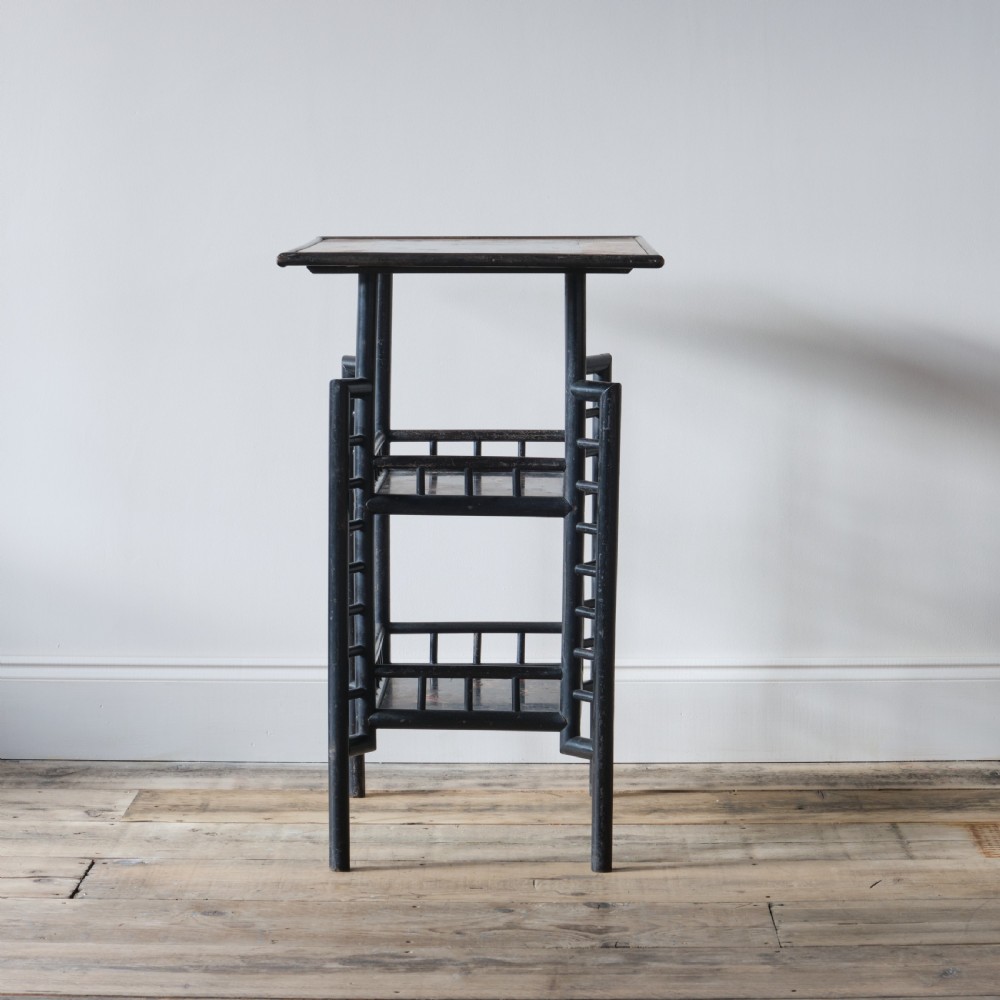 A Victorian Anglo-Japanese ebonised black lacquered three-tier side table featuring lattice side panels and spindled shelf galleries. View V