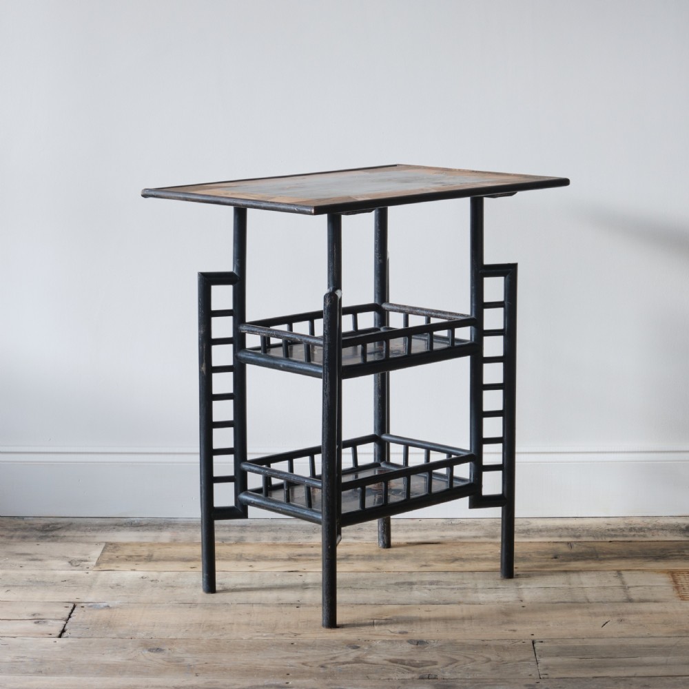 A Victorian Anglo-Japanese ebonised black lacquered three-tier side table featuring lattice side panels and spindled shelf galleries. View VII