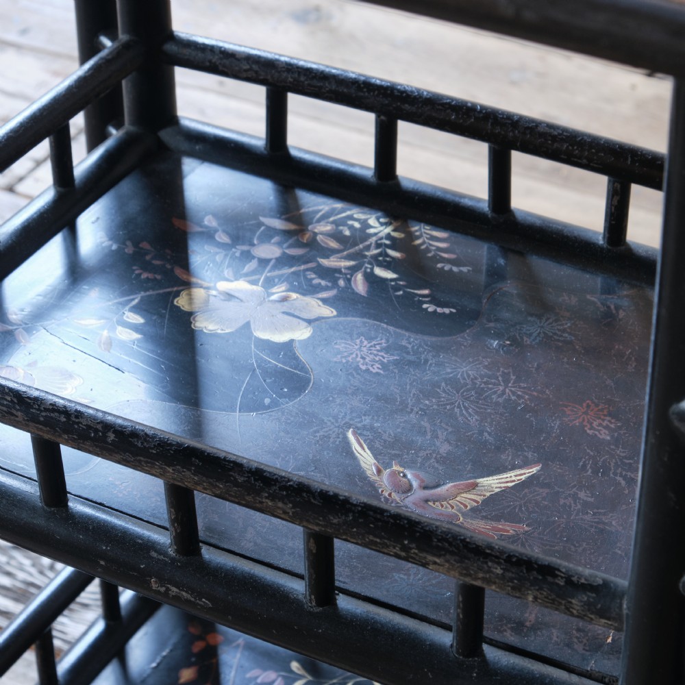 A Victorian Anglo-Japanese ebonised black lacquered three-tier side table featuring lattice side panels and spindled shelf galleries. View X