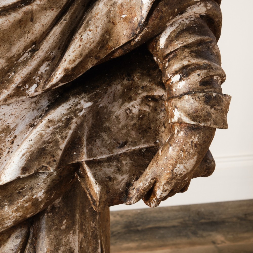 A large freestanding ecclesiastical plaster statue of a saint wearing draped robes, resting on a square pedestal with a distressed brown patinated surface. View VI