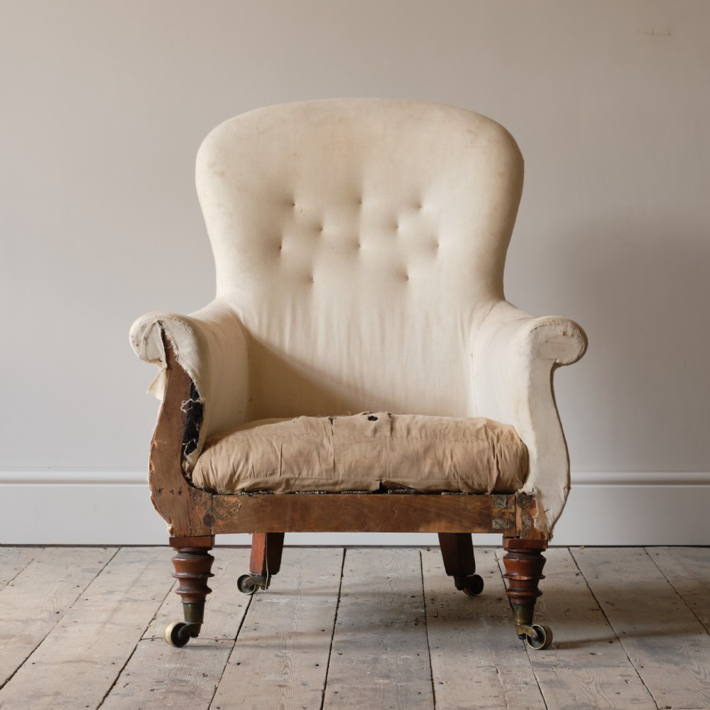 A William IV armchair upholstered in calico fabric featuring turned mahogany front legs fitted with brass castors.