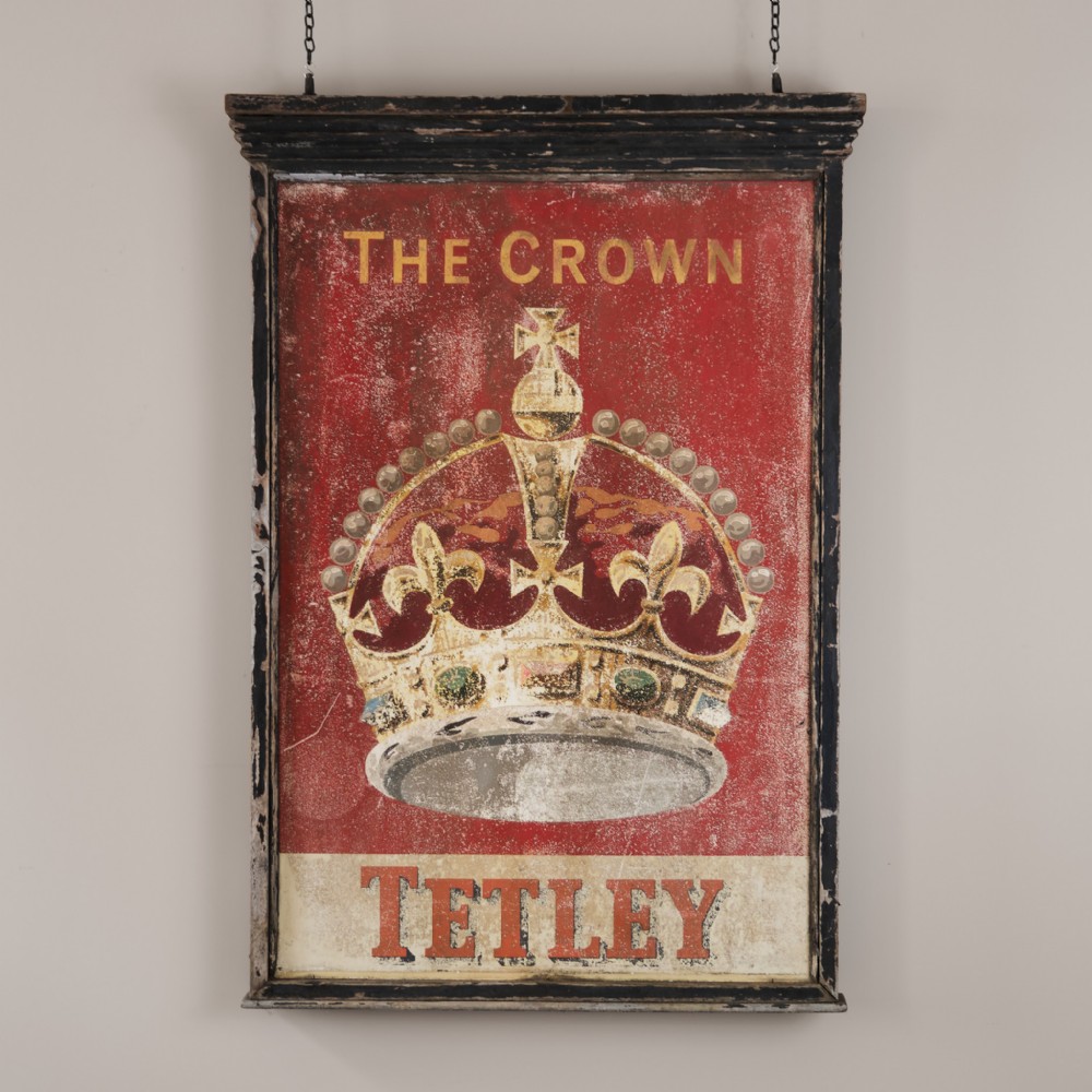 A rectangular double-sided wooden pub sign framed in black moulding featuring the text The Crown above an illustrated gold crown and Tetley branding on a distressed red background.